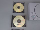three cds and a game controller on a table