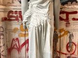 an image of a mannequin wearing a white dress in front of a graffiti covered wall