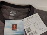 grey t - shirt with a black collar and a tag on it