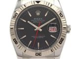 La montre Rolex possède un cadran noir et une trotteuse rouge.