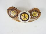a brown and yellow brooch on a white surface