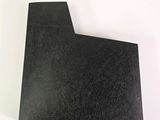 a close up of a piece of black paper on a white surface