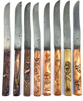 six different types of knives are lined up on a white surface