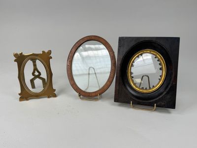 deux petits miroirs et un support de miroir posés sur une surface blanche