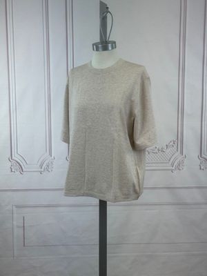 La chemise est posée sur un mannequin devant un mur blanc.