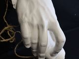 a statue of a hand holding a string on a black background