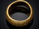 a close up of a gold ring on a black surface