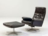 a black leather recliner chair and ottoman in a white room