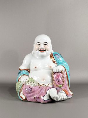 une image représentant une figurine de Bouddha riant, assis sur un coussin