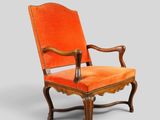 an orange upholstered chair with a wooden frame and armrest