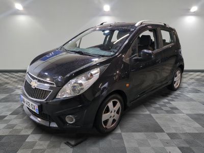la photo d'une petite voiture noire garée sur un sol en damier
