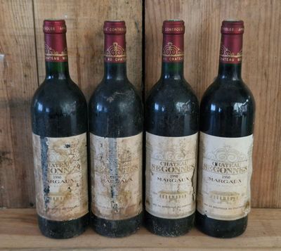 four bottles of wine are lined up on a wooden shelf