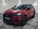 la voiture rouge est garée sur un sol en damier dans le garage