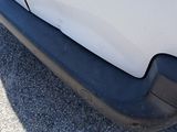 a close up of the front bumper of a white car