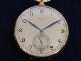 a silver pocket watch with blue hands on a black surface