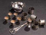 many silver cups and spoons on the table