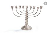 une image représentant une menorah en argent surmontée de cinq bougies