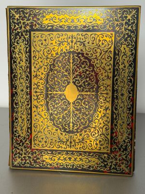 an ornate gold and black book with a clock on the cover