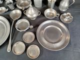 a lot of silverware on a table with a black table cloth