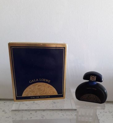 l'image d'un flacon de parfum à côté d'une boîte de parfum