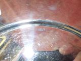 un gros plan d'une personne tenant un téléphone portable dans un bol en verre