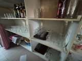 many glasses and bottles on the shelves in the kitchen