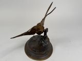statue of a bird perched on a branch on a white background