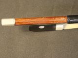 a close up of a bow with a wooden handle on a table