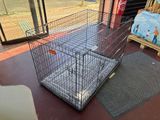 a cage with a dog inside of it on the floor