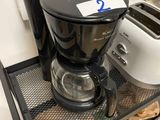 a coffee maker and toaster sitting on a table