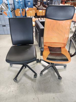 une paire de chaises de bureau noires et orange dans un entrepôt