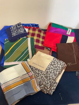 many different types of ties and scarves laid out on a table