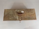 a metal box with a key on it on a white surface