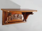 une étagère en bois ornée de sculptures, accrochée au mur