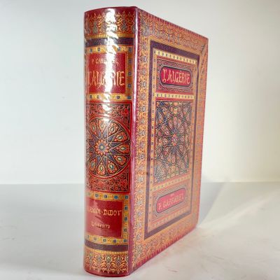 an old book sitting on top of a white table next to a white wall