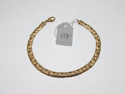 a close up of a gold bracelet with a tag on it