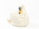 une figurine de cygne blanc posée sur une surface blanche