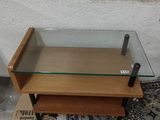 une table basse en verre surmontée d'une étagère en bois