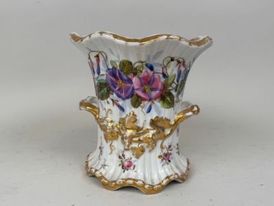 un vase blanc orné de fleurs violettes et jaunes