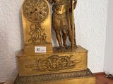 une statue en or représentant un homme tenant un bouclier et un bouclier