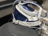a blue and white steam iron sitting on top of an ironing board