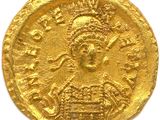 a close up of a gold coin on a white surface