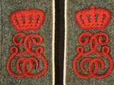 two red and grey patches with crowns on them on a black surface
