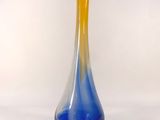 a blue and yellow vase sitting on a white surface