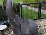 a statue of an elephant that is standing in the gravel
