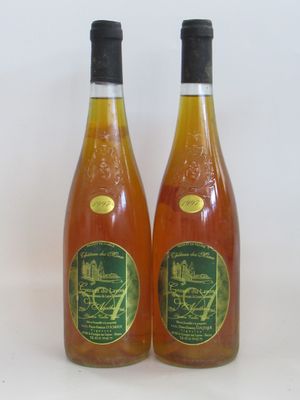 deux bouteilles de vin posées l'une à côté de l'autre sur une surface blanche