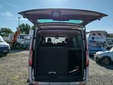 the back of a van with the door open is parked in a parking lot