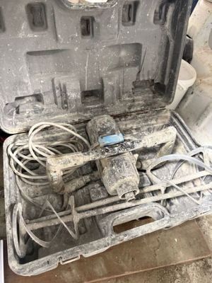 une boîte à outils contenant des outils, posée sur le sol