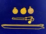 a close up of a group of gold jewelry on a blue surface