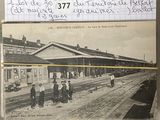 une vieille photo d'une gare où l'on voit des gens debout sur les voies